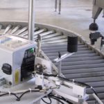 Sistema stampa e applica per applicazione etichetta su due lati di una scatola in movimento