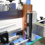 Dispositivo per applicazione fronte e retro su contenitori cilindrici